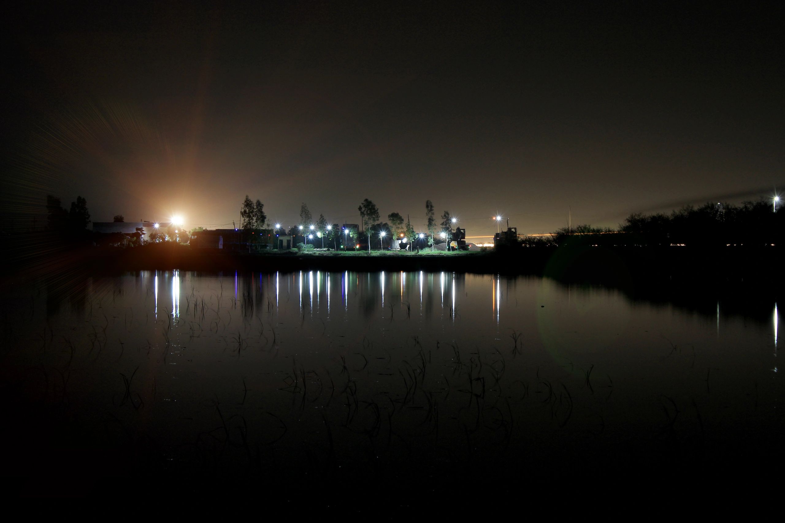 City lights at night near a pond